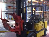 a forklift in a warehouse with pallets in the background