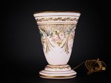 a white vase with gold trim and flowers on it
