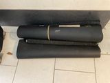 three black yoga mats on the floor next to a black bag