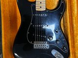 a black electric guitar in a case on the floor