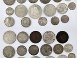 an assortment of silver and bronze coins on a white surface