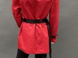 the back view of a mannequin wearing a red coat and black pants