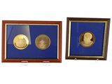 Deux pièces d'or et d'argent, encadrées, sont exposées dans une vitrine.