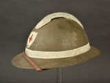 an old army helmet with a red cross patch on the side of it