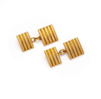 two pairs of gold cufflinks on a white background