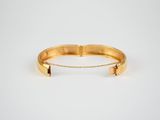 a close up of a gold bracelet with a chain around it