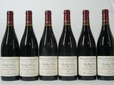six bouteilles de vin sont alignées sur une table