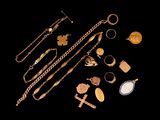 a close up of a bunch of gold jewelry on a black background