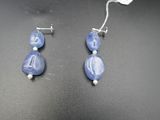 deux paires de boucles d'oreilles en perles de verre bleues et blanches sur un fond noir