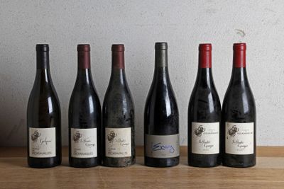 six bouteilles de vin sont alignées sur une table en bois