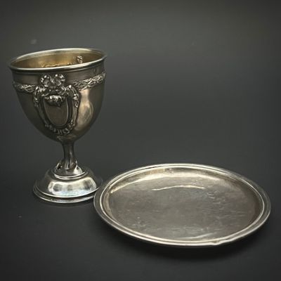 une coupe en argent et une assiette en argent sur fond noir