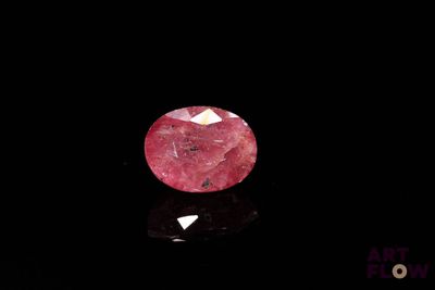 a close up of a pink diamond on a black surface