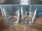two glasses sitting on a table next to a box of wine glasses