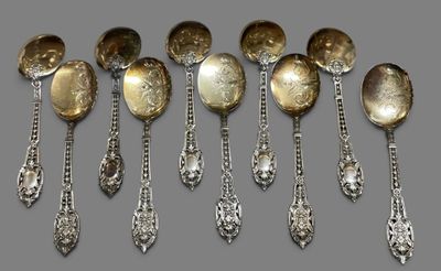 six silver spoons and two silver spoons on a gray surface
