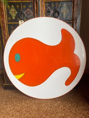 a plate with a fish design on it sitting on the floor