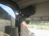 a close up of a window of a bus with a car in the background