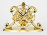 une horloge dorée avec des aiguilles bleues sur fond blanc