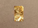 a piece of gold foil on the floor next to a wall