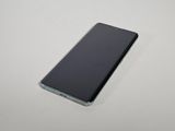 a close up of a cell phone on a white surface