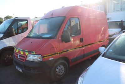 une camionnette rouge garée sur un parking à côté d'autres voitures