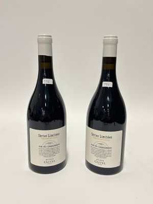 deux bouteilles de vin rouge posées l'une à côté de l'autre sur une surface blanche