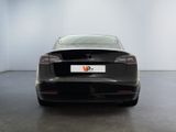 the back of a black tesla model s parked in a white room