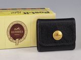 un portefeuille en cuir noir orné d'un bouton doré