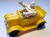 un petit camion jaune avec un homme à l'intérieur
