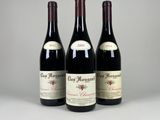 trois bouteilles de vin rouge posées sur une table