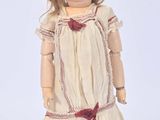 a doll that is wearing a dress and a hat