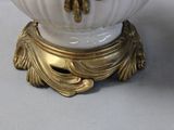 a white vase with a gold decoration on it