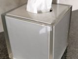 a tissue dispenser sitting on a counter in a bathroom