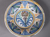 a blue and yellow plate with a flower design on it