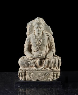 une statue blanche représentant une femme assise sur une table noire