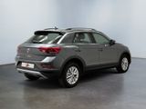 the rear view of a grey volkswagen suv parked in a showroom