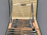 a green case with a set of knives in it