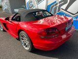 a red sports car parked in front of a graffiti covered wall