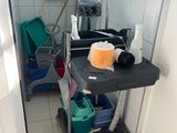 a cat that is sitting on a cart in the bathroom