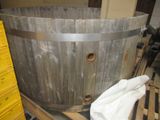 un grand tonneau en bois posé sur une palette dans un entrepôt