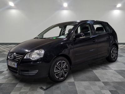 la voiture noire est garée sur un sol en damier dans le garage