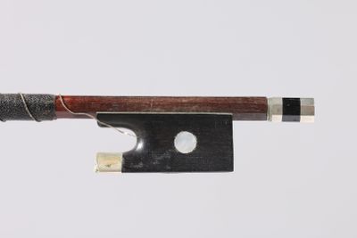a close up of a violin bow with a piece of wood sticking out of it