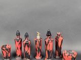 several red and black vases are lined up against a gray background