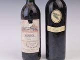 two bottles of wine sitting next to each other on a white surface
