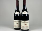deux bouteilles de vin rouge posées l'une à côté de l'autre sur une table