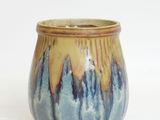 a blue and yellow vase with a mountain design on it