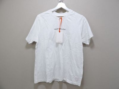 Le t-shirt blanc est suspendu à un cintre accroché au mur.