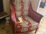a chair that has a book on it in front of a fireplace