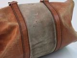 a brown and tan bag sitting on a white table