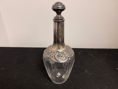 une image représentant une bouteille en verre ornée d'un décor argenté sur le goulot