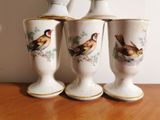 three vases with birds painted on them sitting on a table